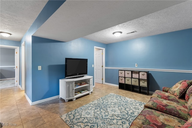 tiled living room featuring a textured ceiling