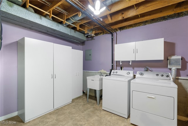 clothes washing area with electric panel, washing machine and clothes dryer, and cabinets