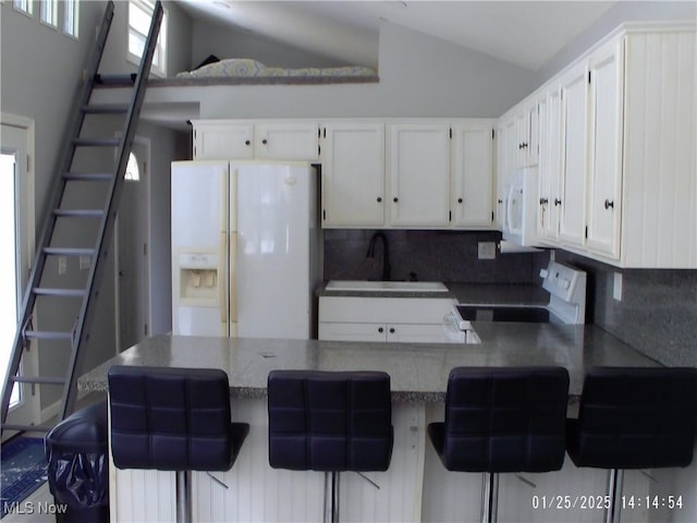 kitchen with white appliances, a kitchen bar, and decorative backsplash