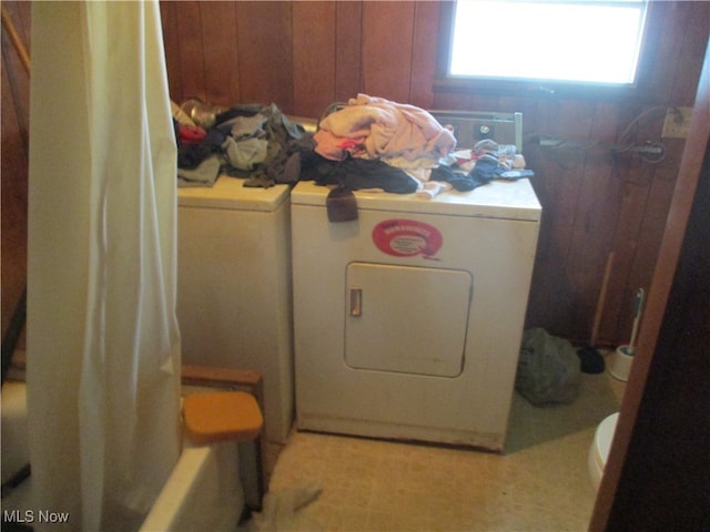 washroom featuring separate washer and dryer and wooden walls