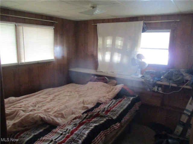 bedroom featuring wood walls and ceiling fan