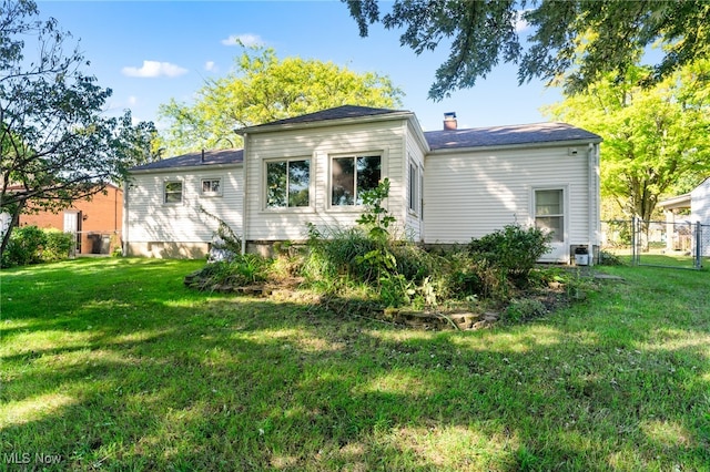 rear view of house featuring a lawn