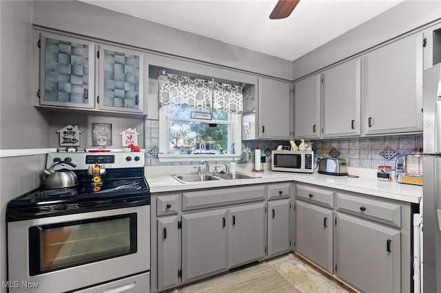 kitchen with ceiling fan, sink, tasteful backsplash, gray cabinetry, and stainless steel appliances