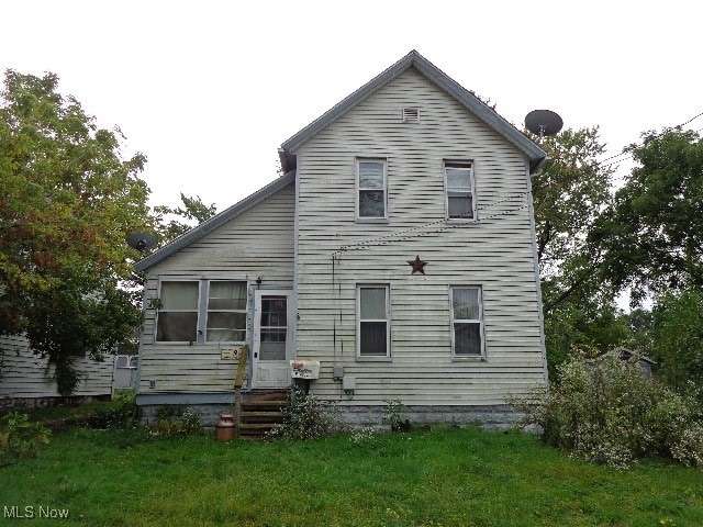 back of property featuring a yard