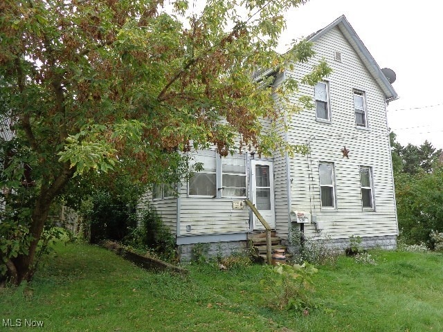 view of side of property with a lawn