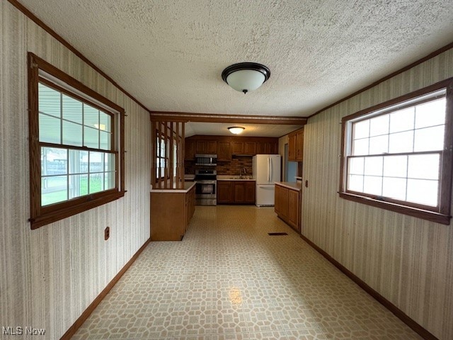 kitchen featuring ornamental molding, stainless steel appliances, and a wealth of natural light