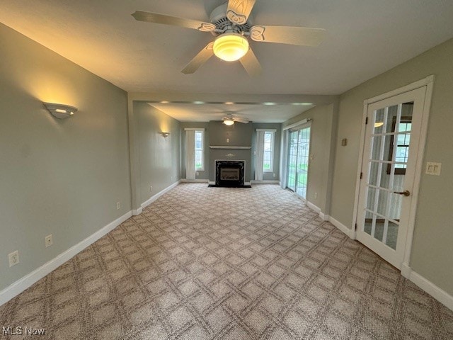 unfurnished living room featuring ceiling fan and light colored carpet