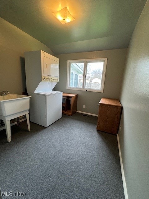 clothes washing area with carpet flooring and stacked washing maching and dryer