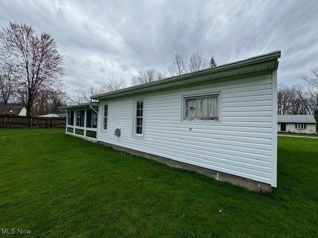 view of side of home with a lawn and a sunroom