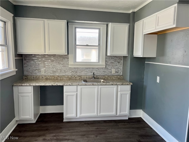 kitchen featuring white cabinets, ornamental molding, sink, tasteful backsplash, and dark wood-type flooring