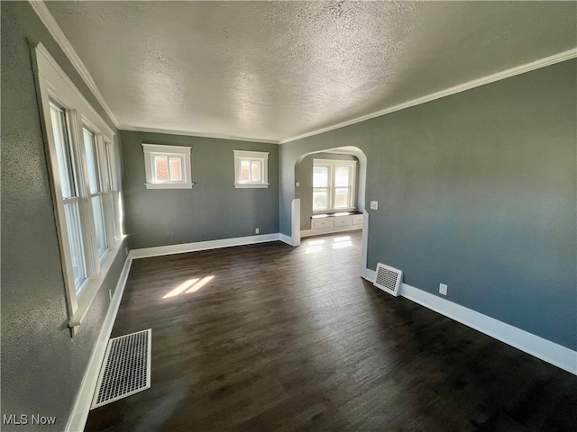 unfurnished room featuring ornamental molding, dark hardwood / wood-style flooring, and a wealth of natural light