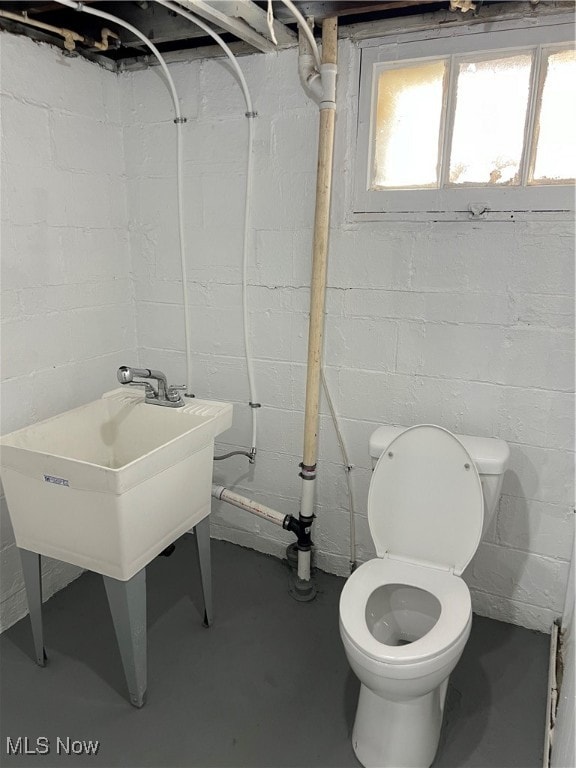 bathroom with toilet and concrete flooring