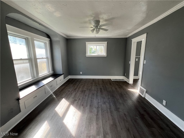 spare room with a textured ceiling, ornamental molding, dark hardwood / wood-style flooring, and ceiling fan