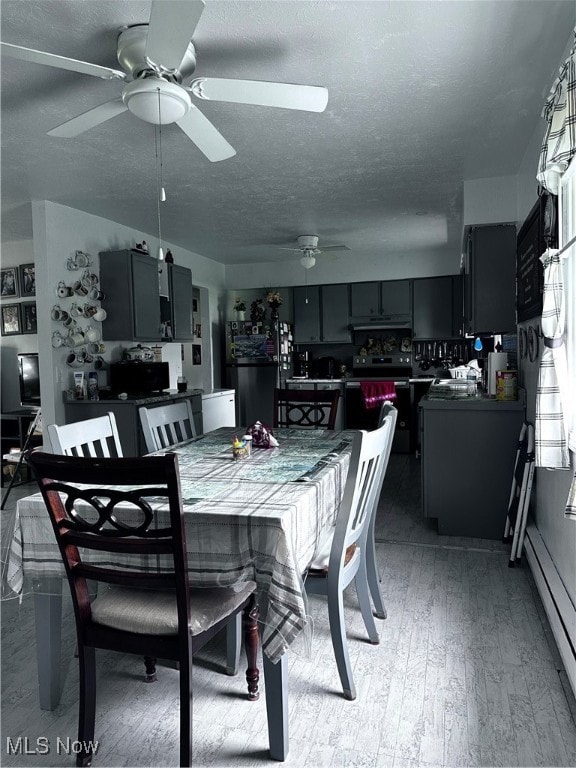 dining area featuring a baseboard radiator, light wood-type flooring, a textured ceiling, and ceiling fan