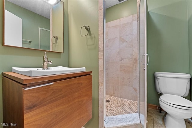 bathroom with walk in shower, vanity, toilet, and tile patterned floors