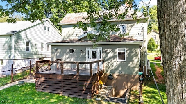 rear view of property featuring a deck and a yard