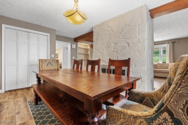 dining space with a textured ceiling and light wood-type flooring