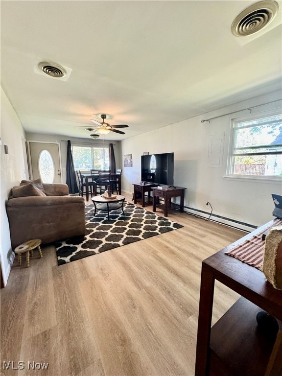 living room with wood-type flooring, ceiling fan, and baseboard heating