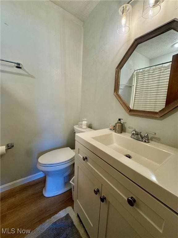 bathroom with vanity, hardwood / wood-style floors, and toilet