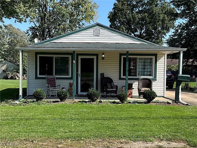 bungalow-style home with a front yard and covered porch