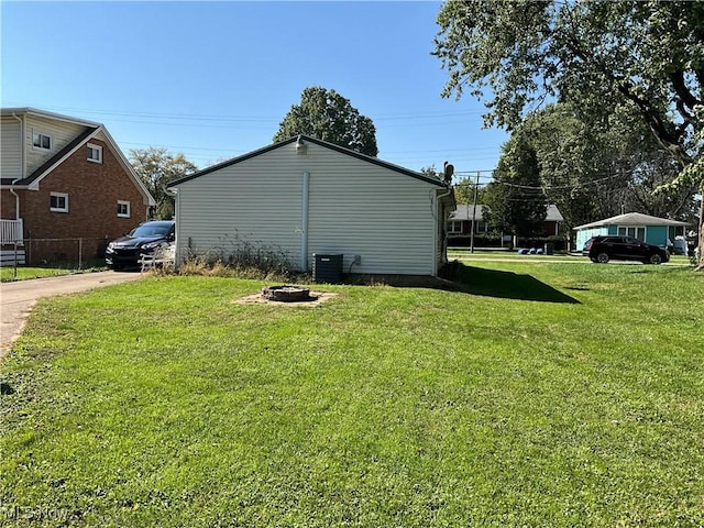 view of side of property with a lawn and a fire pit