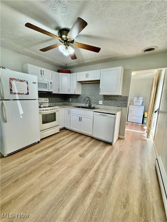 kitchen featuring sink, light hardwood / wood-style flooring, a baseboard radiator, white appliances, and white cabinets