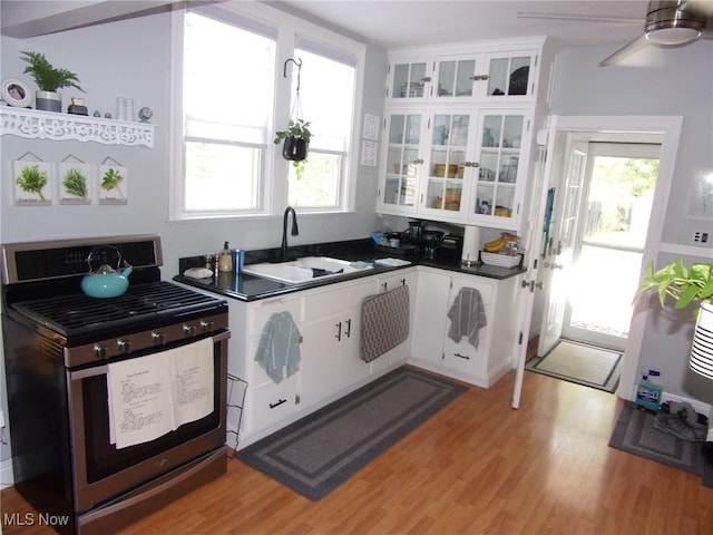 kitchen featuring electric stove, a wealth of natural light, sink, and white cabinetry