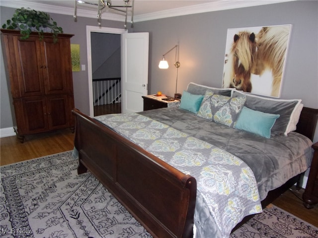 bedroom with ornamental molding and light hardwood / wood-style flooring