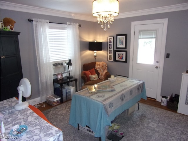 bedroom with dark hardwood / wood-style floors, ornamental molding, multiple windows, and a chandelier