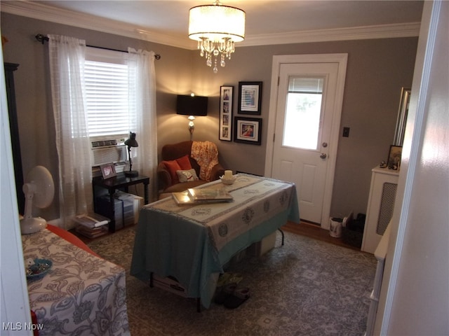 bedroom featuring cooling unit, crown molding, and a chandelier