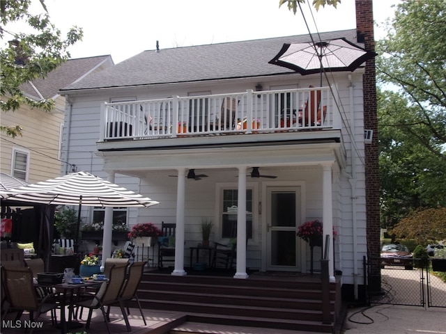 back of house with a balcony and ceiling fan