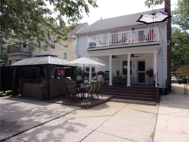 rear view of property with a gazebo, a balcony, and ceiling fan