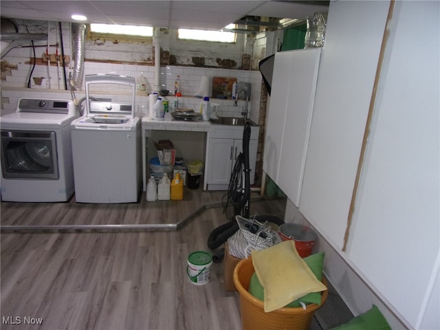 washroom featuring cabinets, independent washer and dryer, hardwood / wood-style floors, and sink