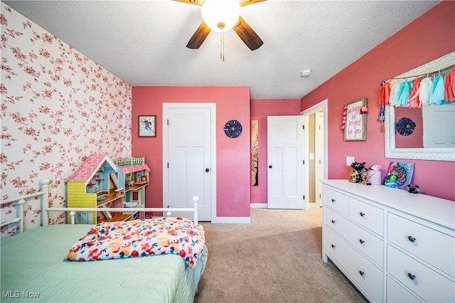 carpeted bedroom featuring ceiling fan and a textured ceiling