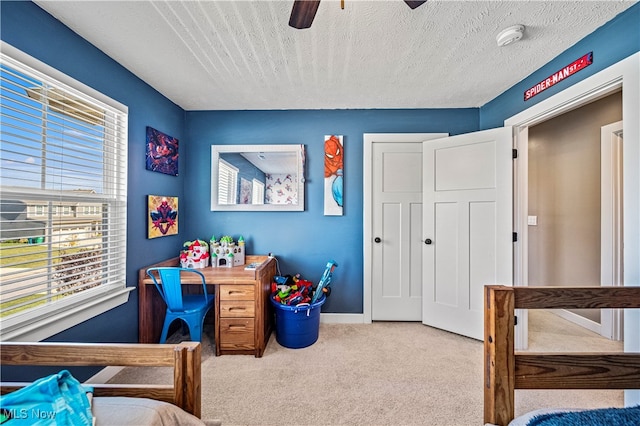 bedroom featuring a textured ceiling, ceiling fan, and light colored carpet