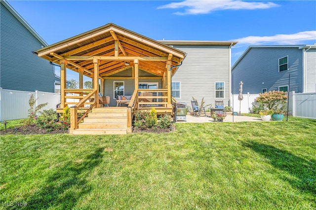 back of property with a patio, a yard, ceiling fan, and a deck