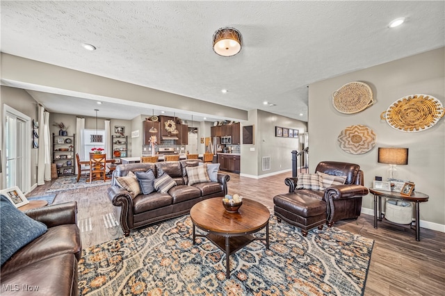 living room with a textured ceiling and hardwood / wood-style floors