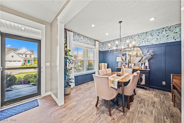 dining area with hardwood / wood-style flooring, a textured ceiling, and a healthy amount of sunlight