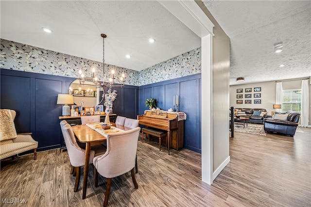 dining space with a textured ceiling and hardwood / wood-style flooring