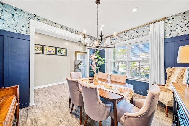 dining area with light hardwood / wood-style flooring and a notable chandelier