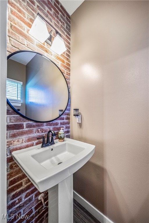 bathroom with brick wall