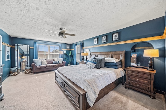 carpeted bedroom with ceiling fan and a textured ceiling