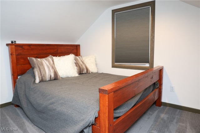 bedroom featuring dark colored carpet and vaulted ceiling