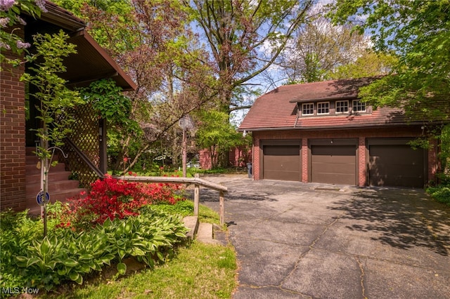 view of yard featuring a garage and an outbuilding