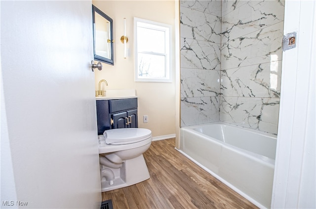 full bathroom featuring wood-type flooring, vanity, toilet, and tiled shower / bath combo