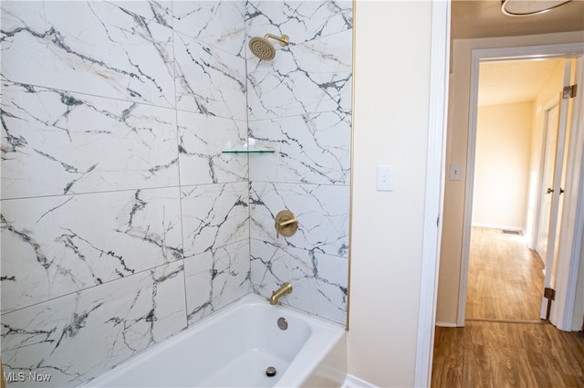 bathroom with wood-type flooring and tiled shower / bath combo