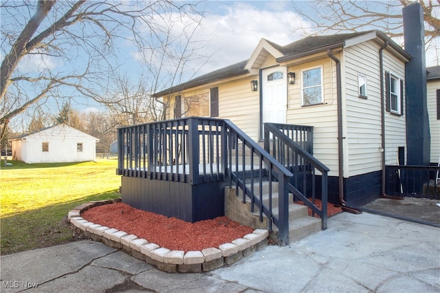 view of front facade with a wooden deck and a front lawn