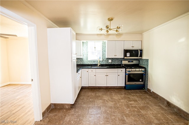 kitchen with appliances with stainless steel finishes, tasteful backsplash, sink, and white cabinets