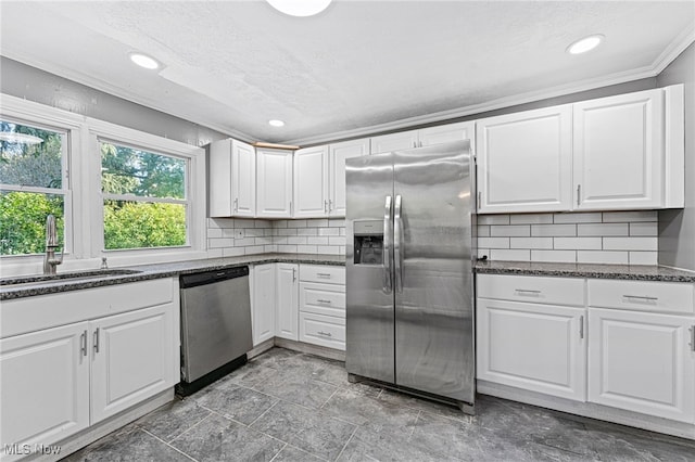 kitchen featuring decorative backsplash, white cabinetry, appliances with stainless steel finishes, and sink