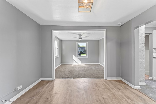 empty room with ceiling fan and light wood-type flooring